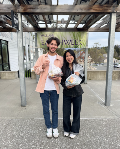 Brian and Yunae two students hold side by side holding up small clear bags of trash